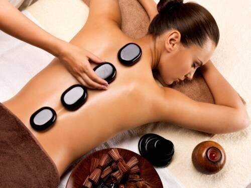 beautiful woman relaxing in spa salon with hot stones on body Esprit Frome